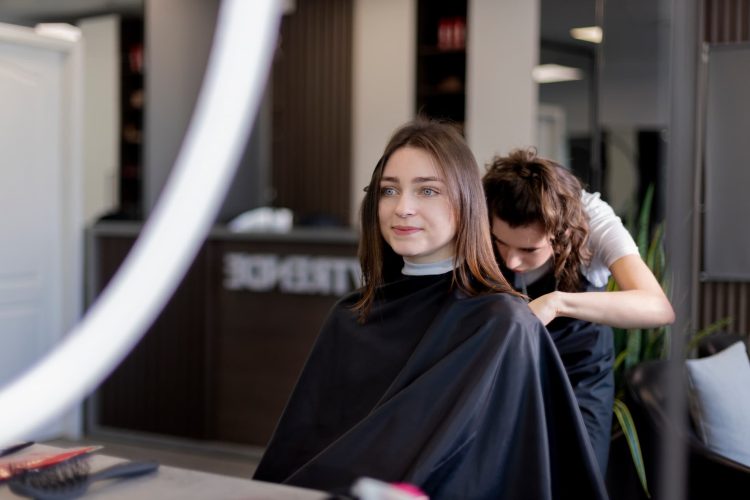 Fryzjer przygotowuje włosy klientki do modelowania i stylizacji w salonie fryzjerskim.